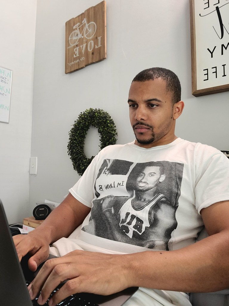 DC EASY sitting on a bed using a laptop computer